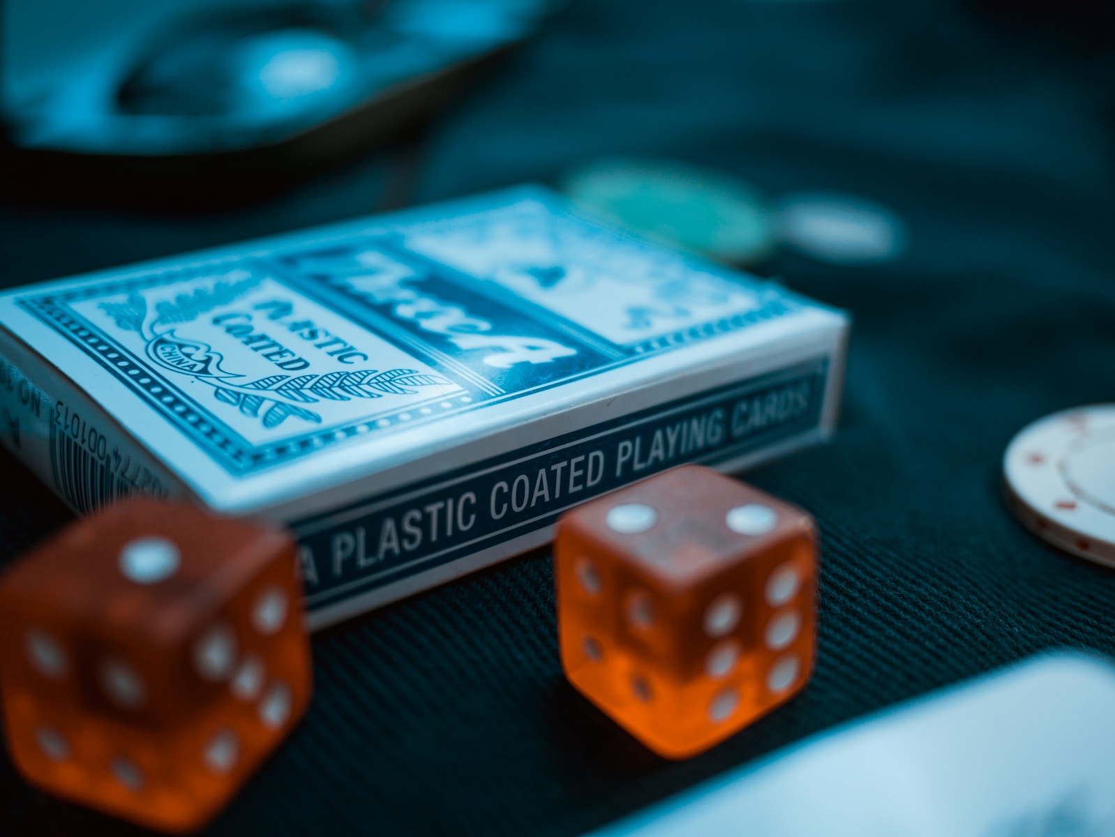 two orange dices beside card deck